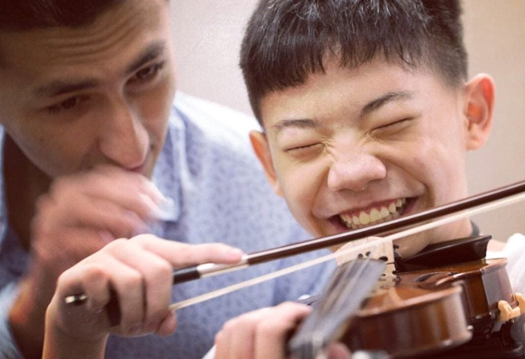 Dior guiding a young student at the Singapore International String Conference